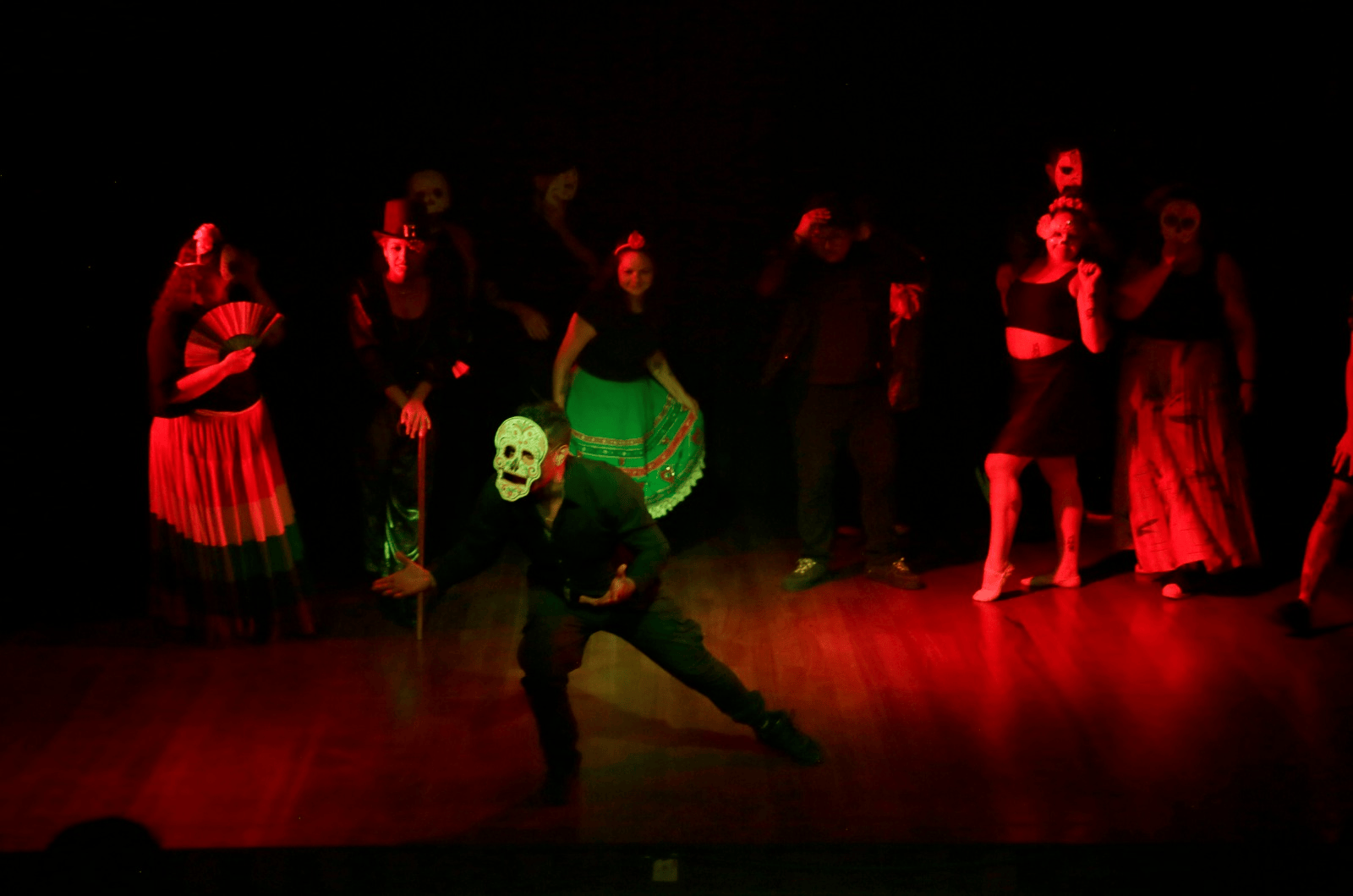 Diversos artistas no palco, encenando uma peça teatral.